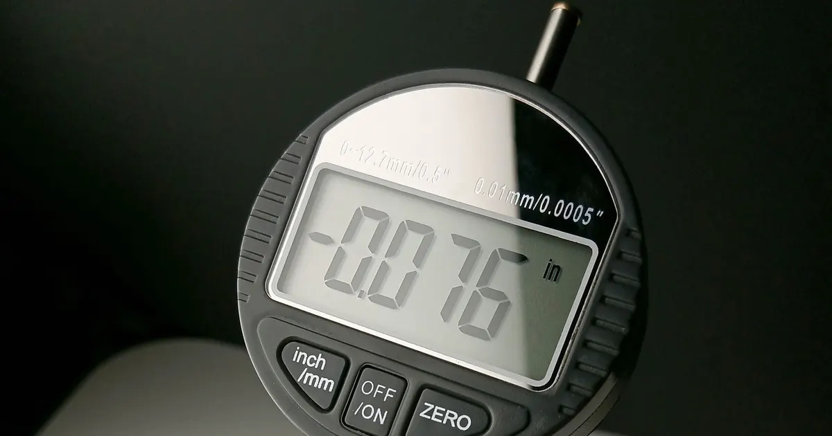 Digital indicator gauge with a measurement readout, representing the measurements summarised in a CMM inspection report