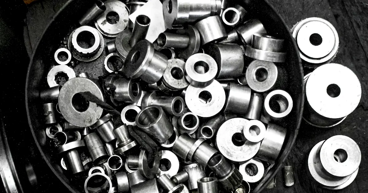 Tray of small turned metal parts with finished edges, illustrating a deburring specification for machined parts