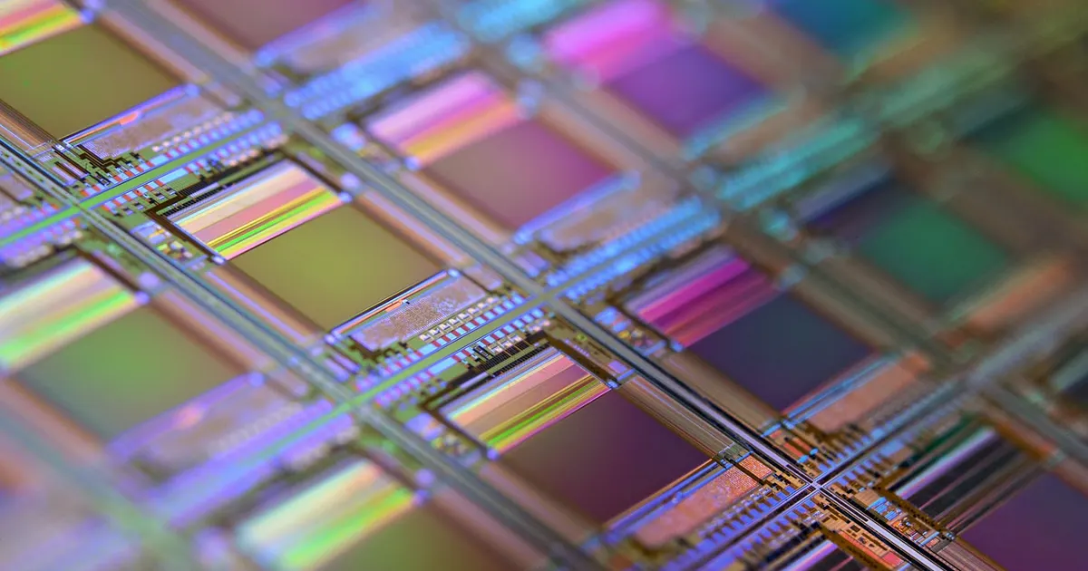 Close view of a silicon wafer with a grid of microchip dies, the product made by equipment that uses semiconductor machined parts